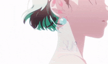 a close up of a woman 's neck and ears with green hair .