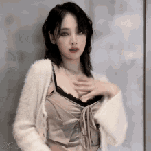 a woman wearing a white sweater and a bra with the letters zc on the bottom right