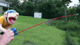 a stuffed animal is holding a fishing rod in a field .