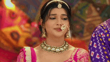 a woman is wearing a nose ring and a necklace