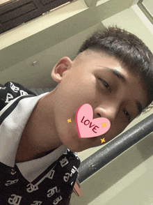 a young man with a pink heart that says love on it