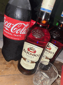 a bottle of alfonso light alcohol next to a bottle of coca cola