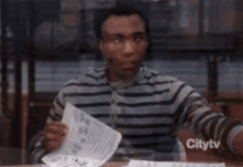Looking Serious Noted GIF - Looking Serious Noted Turns Paper Upside Down GIFs