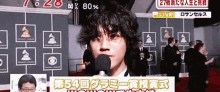 a man talking into a microphone with a sign that says live