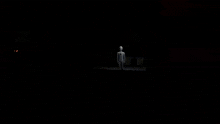 a person is standing in a dark room with a light shining on them .