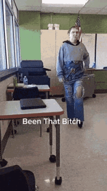 a person standing in a classroom with the words been that bitch written on the floor