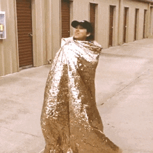 a woman is wrapped in a foil blanket and wearing a hat