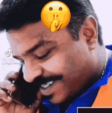 a man is talking on a cell phone with a smiley face on his face