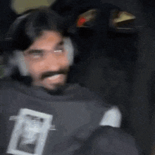 a man with a beard wearing headphones is smiling