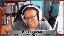 a woman wearing headphones and glasses is sitting in front of a sign that says ' d hane monk ' on it