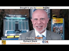 a man in a suit and tie is standing in front of a jukebox and smiling .
