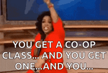 a woman in a red dress is holding a microphone and saying you get a co-op class and you get one ... and you