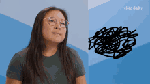 a woman wearing glasses is standing in front of an elite daily ad