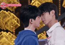 two boys are kissing in front of a sign that says boys planet