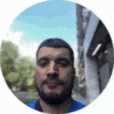 a man with a beard is standing in a circle and looking at the camera .