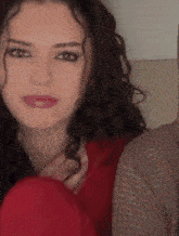 a woman with curly hair wearing a red shirt