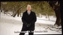 a man in a suit and tie is standing in the snow on london tonight itv