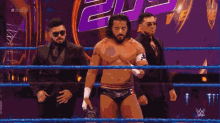 a man in a wrestling ring holding a trophy with the number 20 on the back