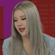 a close up of a woman with long gray hair making a funny face .