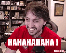 a man in a red shirt is laughing and has the word  hahaha written on his chest