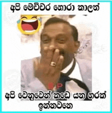 a man in a suit and tie is laughing with his hand on his mouth .