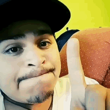 a man wearing a hat giving a thumbs up sign