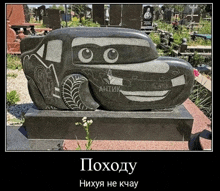 a statue of lightning mcqueen from cars is in a cemetery .