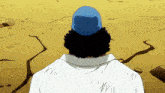 a man wearing a blue hat and a white shirt is standing in the desert