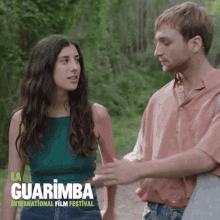 a poster for the guarimba international film festival shows a man and a woman holding hands