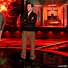 a man with his arms crossed stands in front of a screen that says joequininggifs