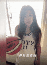 a woman holding a molten basketball with chinese writing on the bottom