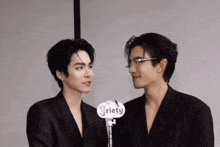 two men are standing next to each other with a sign that says riety on it