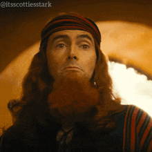a man with long red hair and a beard has the hashtag @itsscottiesstark on the bottom right