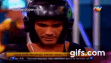 a man wearing a helmet is looking at the camera while on a tv show .