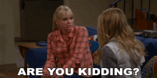 two women are sitting on a couch and one of them is asking the other " are you kidding "