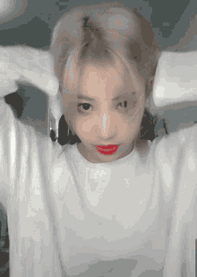 a woman with blonde hair and red lipstick looks at the camera