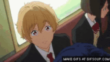 a boy in a suit and tie is sitting next to a girl on a train .
