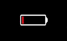 a white battery with a red stripe on the bottom of it is shown on a black background .