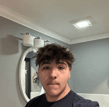 a young man taking a selfie in front of a mirror