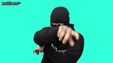 a man wearing a black hoodie and a black beanie is doing a dab