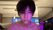 a man without a shirt has a purple alien on his chest