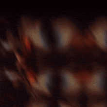 a blurred image of a man holding a gun in front of a wall