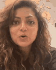 a close up of a woman 's face with a world map in the background