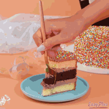 a person is taking a piece of cake with a fork from a cake with sprinkles