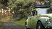 a disney car is driving down a road with luggage on the roof