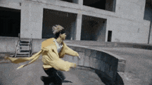 a person in a yellow jacket is running in front of a building with the number 1 on it