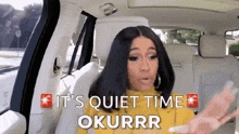 a woman sitting in the back seat of a car with the words " it 's quiet time okurrr " above her