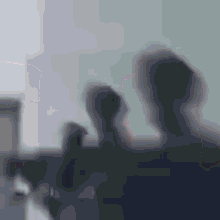a blurry photo of a group of people standing next to each other in a room .