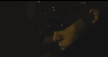 a man in a hat is standing next to a man in a mask in a dark room .