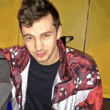 a young man wearing a red jacket with white crosses on it